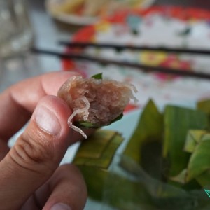 Tomek wcina surowe mięso wyjęte z opakowania w postaci liścia bananowca